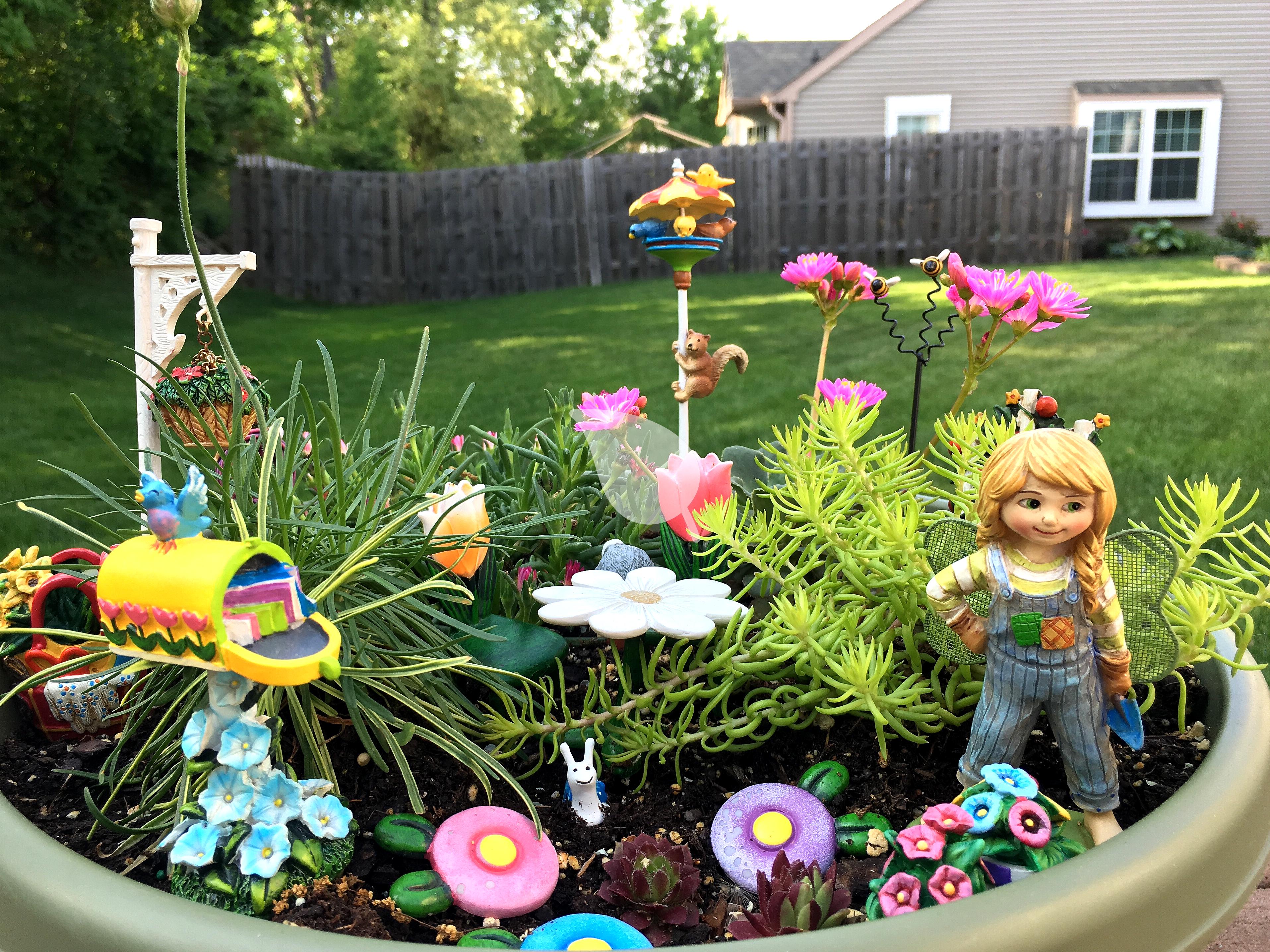 Colorful fairy garden in an old toolbox with children planting