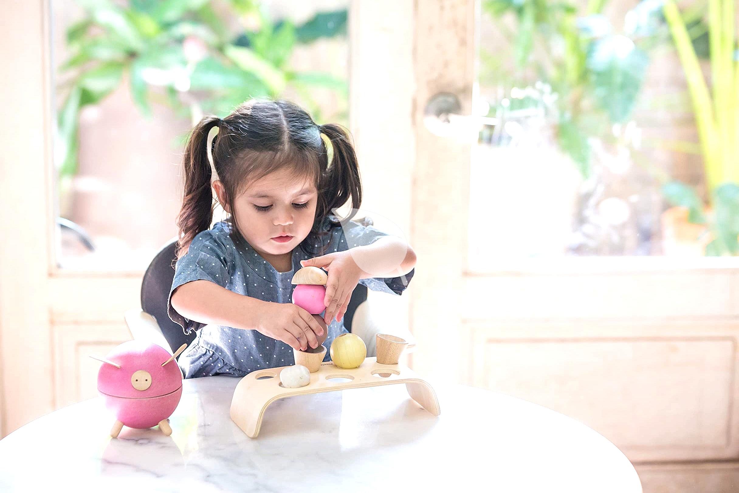 Toddler happily playing outdoors with natural materials in eco-friendly activities