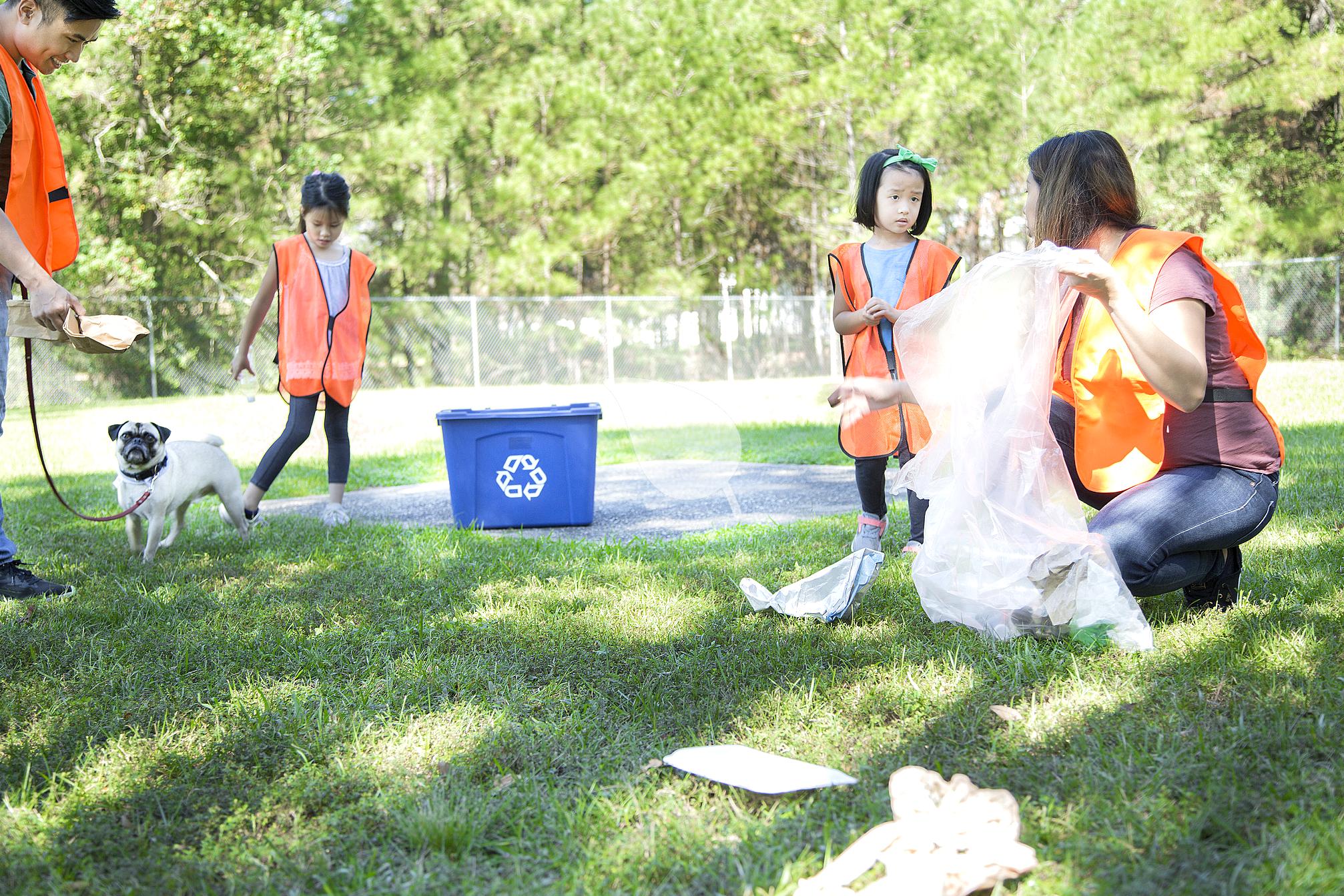 Kids collecting trash during family park cleanup