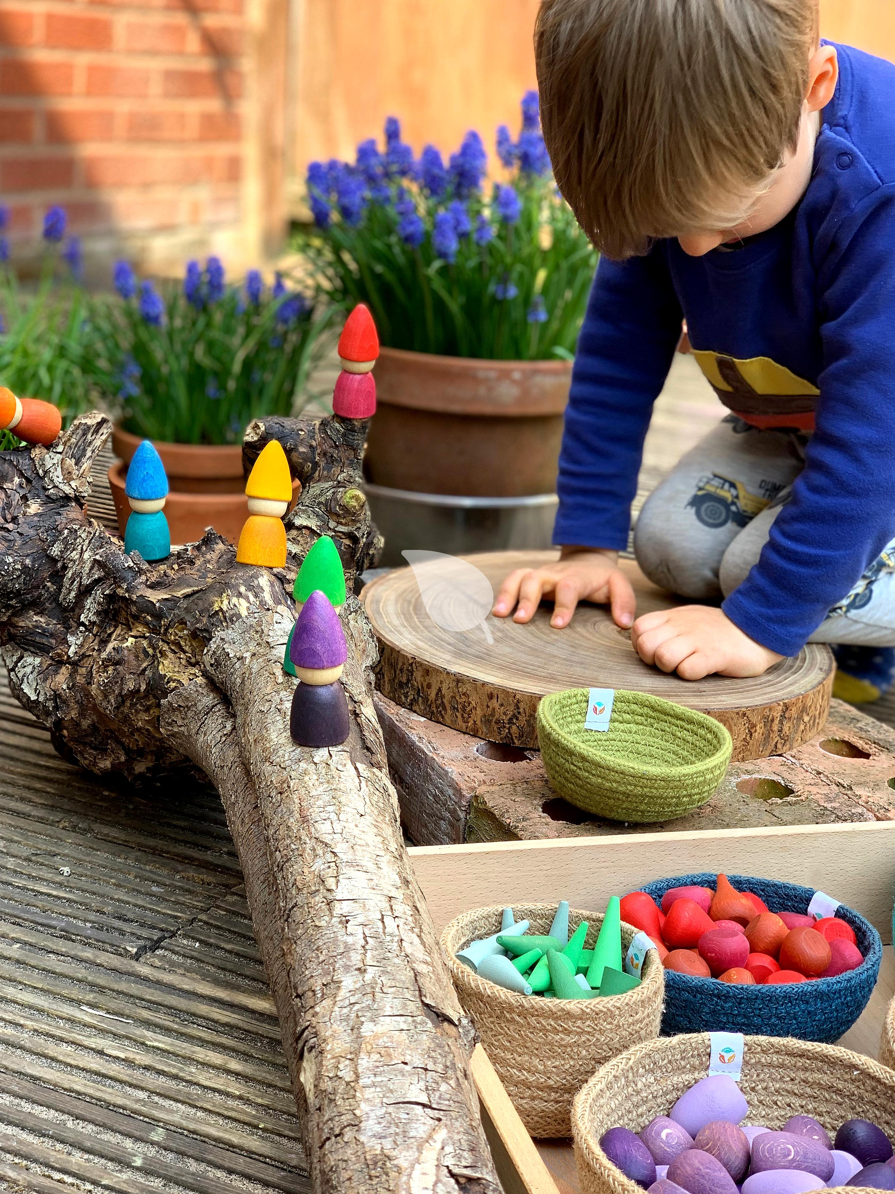 Toddler engaging in imaginative play with wooden toys